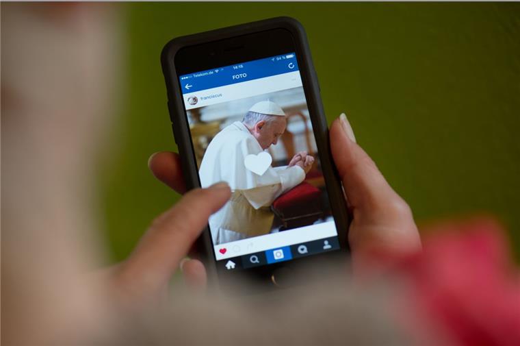 Der Papst ist jetzt bei Instagram Ein Frau hält ein Smartphone mit dem Instagram-Account von Papst Franziskus in den Händen. Der Papst wird künftig unter "Franciscus" Fotos und kurze Videos auf der Foto-Plattform mit Nutzern in aller Welt teilen.