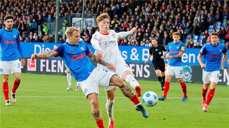  Kiels Tymoteusz Puchacz (l) und Heidenheims Paul Wanner kämpfen um den Ball.
