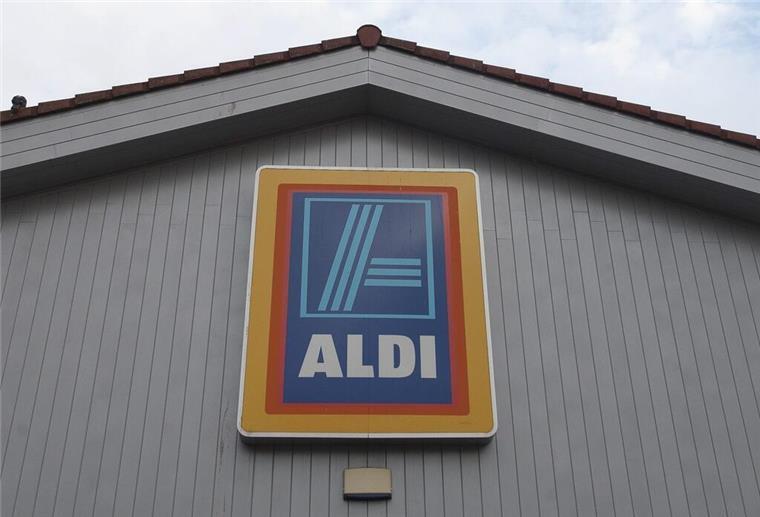 Das Logo von Aldi hängt an einer Filiale in England.