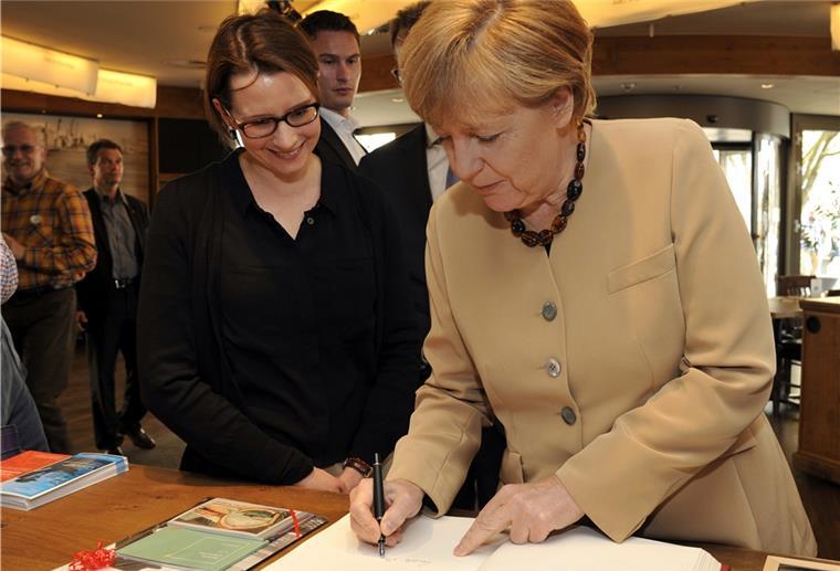 Kanzlerin Merkel mag Bremerhaven Bundeskanzlerin Angela Merkel schreibt sich ins Gästebuch des Deutschen Auswandererhauses ein.