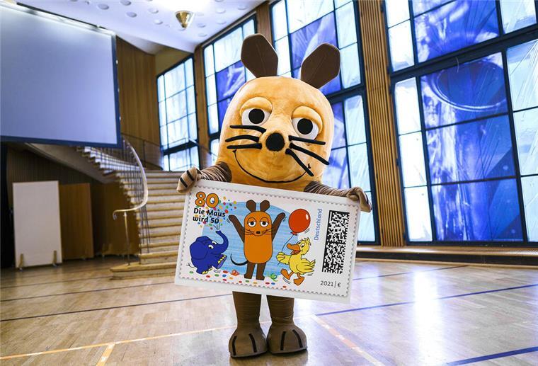 HANDOUT - 24.02.2021, Nordrhein-Westfalen, Köln: Die Hauptdarstellerin der Sendung mit der Maus hält eine überdimensionale Briefmarke mit ihren Darsteller-Kollegen Elefant und Ente in den Händen. Die «Sendung mit der Maus» bekommt eine eigene Briefmarke. Rechtzeitig vor dem 50. Geburtstag der ARD-Sendung erscheint am nächsten Montag (1. März) eine 80-Cent-Sondermarke mit Maus, Elefant und Ente, wie der WDR am Mittwoch in Köln mitteilte. Foto: Ben Knabe/WDR/dpa - ACHTUNG: Nur zur redaktionellen V