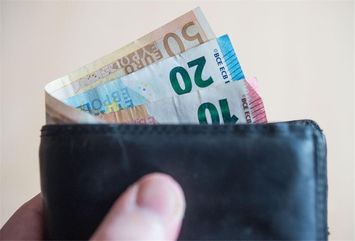 Geldscheine im Wert von zehn, zwanzig, und fünfzig Euro stecken in einem Geldbeutel