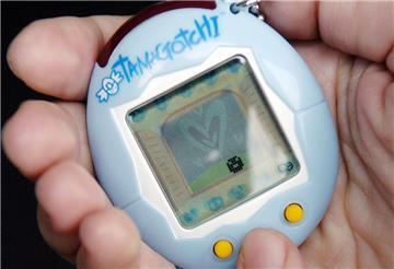 Ein Tamagotchi liegt in einer Hand. 