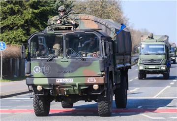 Militärfahrzeuge fahren über eine Straße.