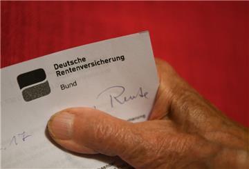 Eine Rentnerin hält ihren Rentenbescheid in der Hand. (zu dpa: «Umfrage: Jeder Vierte will vorzeitig in Rente»)