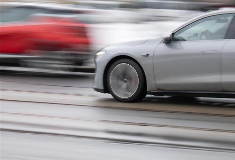 Ein graues und ein rotes Auto drängeln im Straßenverkehr.