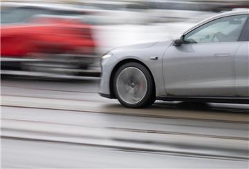 Ein graues und ein rotes Auto drängeln im Straßenverkehr.
