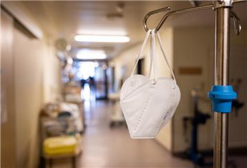 In einem Flur der Intensivstation in der Coronapatienten mit schweren Krankheitsverläufen behandelt werden hängt eine Mund-Nasen-Schutz Maske.
