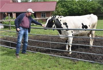 Das Foto zeigt Jan Kaiser mit einer Kuh auf der Weide.