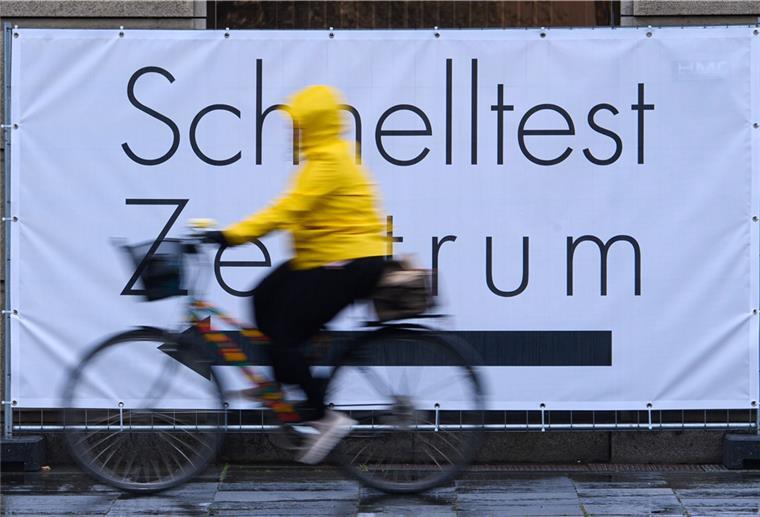 Corona-Schnelltests ab 11. Oktober meist nicht mehr kostenlos Eine Fahrradfahrerin fährt an einem Banner mit der Aufschrift "Schnelltest Zentrum" vorbei.