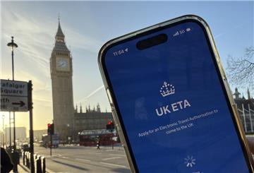 Ein Handy, auf dem die "UK ETA"-App läuft. Im Hintergrund steht der Big Ben. Ab April brauchen Besucher, die nach Großbritannien einreisen wollen, eine Einreisegenehmigung.