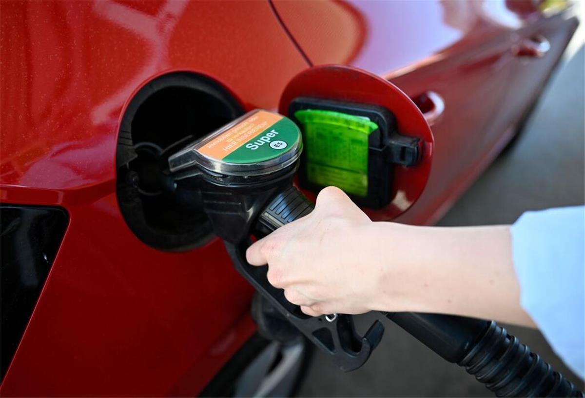 Ein rotes Auto wird getankt. 