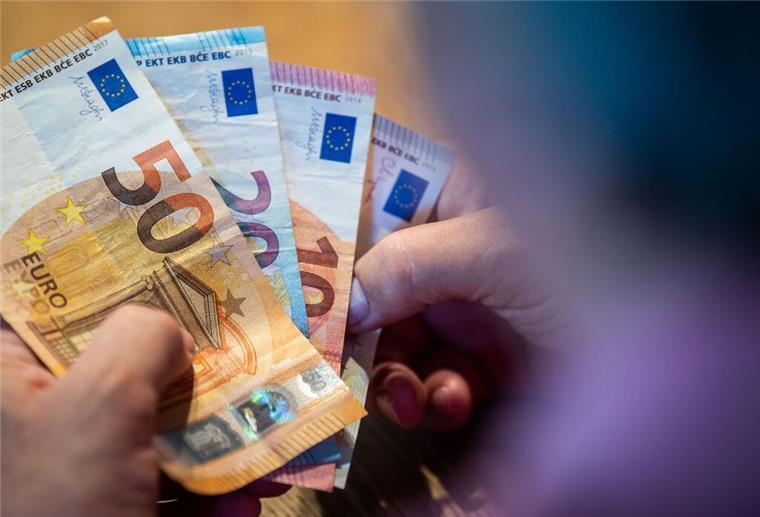 Ein älterer Mann zählt Geld an einem Tisch. Ab Juli 2025 gibt es mehr Geld für viele Rentner – die Rente und der Zuschlag zur Erwerbsminderungsrente steigen gemeinsam um 3,74 Prozent.