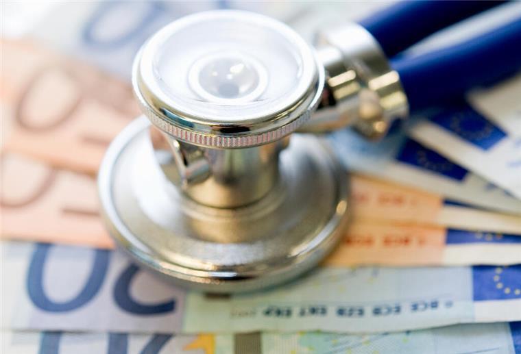Geldscheine liegen auf einem Tisch. Darüber liegt ein Stethoskop. Ab Juli 2025 müssen sich Privatversicherte auf eine spürbare Beitragserhöhung einstellen.