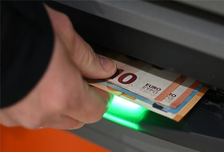 Zahlungen mit Bargeld ab 2027 beschränkt! Diese Änderungen bringt die neue Regel Ein Mann zieht Geldscheine aus dem Ausgabefach eines Geldautomaten.