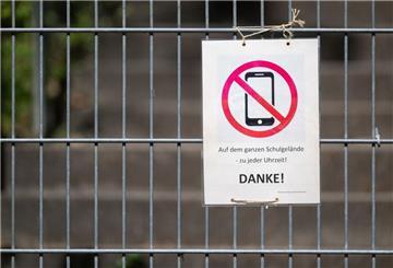 Ein Schild mit einem durchgestrichenen Smartphone und der Aufschrift «Auf dem ganzen Schulgelände - zu jeder Uhrzeit! DANKE!»