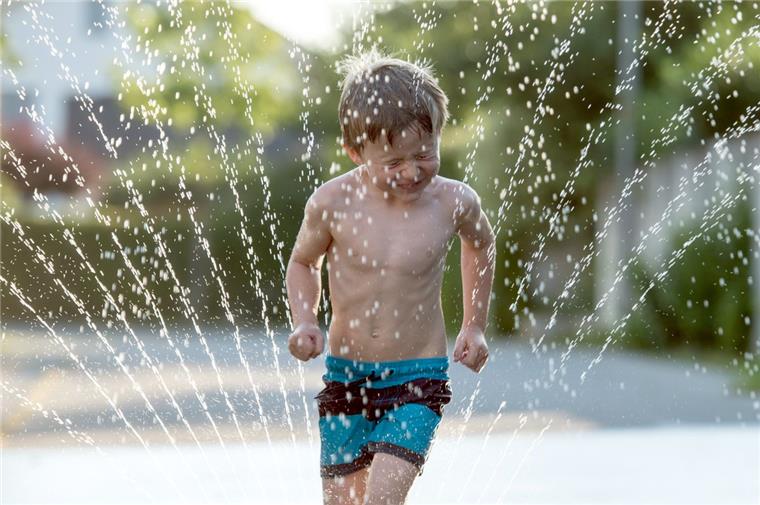 Wesermarsch: Hitzewelle sorgt für Rekordniveau beim Wasserverbrauch Abkühlung während der Hitzewelle: Kinder genießen gerne die Wasserstrahlen eines Rasensprengers, der den Rasen grün halten soll. Dabei wird allerdings auch viel Wasser verbraucht.