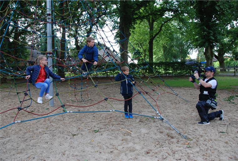 Lunestedt: Grundschüler kommen vor der Kamera groß raus Achtung, Aufnahme: Kameramann Frank Besl lässt (von links) Swantje, Henrik und Mika auf dem großen Klettergerät der Grundschule erzählen, wie gut es sich hier lernen und spielen lässt.
