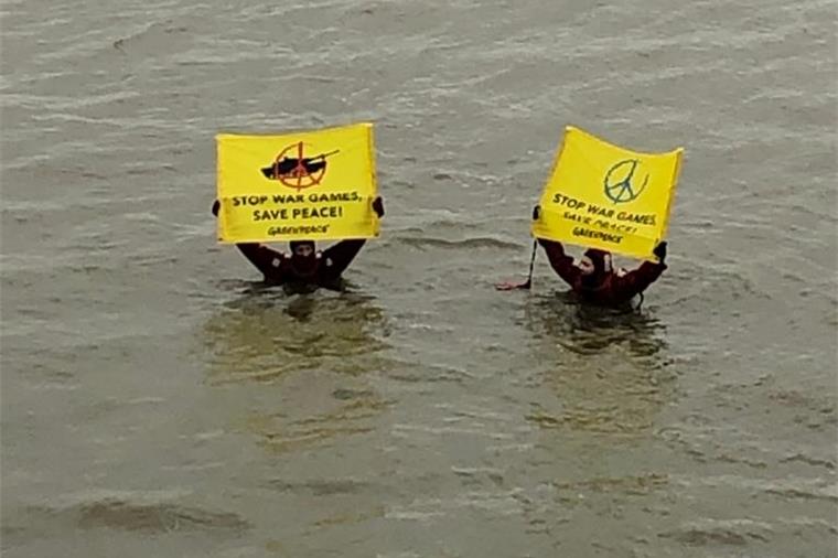 Bremerhaven: Greenpeace behindert Militärtransport Aktivisten von Greenpeace halten Plakate in die Luft.