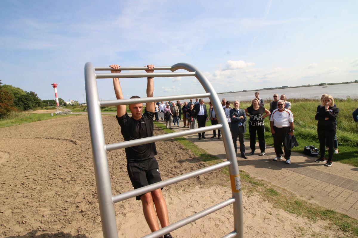 Alex Golowtschenko zeigt den Gästen, wie die Fitnessgeräte in Nordenham funktionieren.