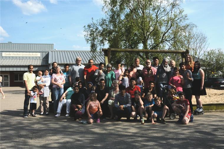Wremer Flüchtlingshelfer suchen Unterstützer Alle gemeinsam für eine bessere Welt: Die Wremer Flüchtlingshelfer mit ihren Schützlingen.