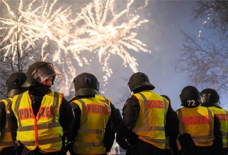 Angriffe auf Rettungskräfte: So rüstet sich die Polizei für Silvester Polizeibeamte stehen in Hannover in der Innenstadt und beobachten ein Feuerwerk.
