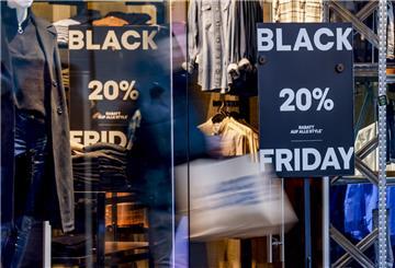 Besucher der Kieler Innenstadt besuchen Ladengeschäfte, die für den Black Friday werben