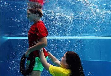  Leo und Marlene demonstrieren mit einem Tauchring die Rettung einer Person aus einem Schwimmbecken.