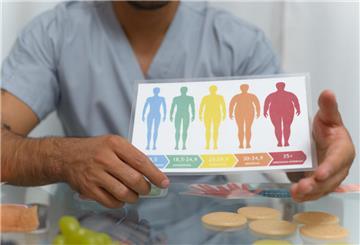 Eine medizinische Fachkraft zeigt den Body-Mass-Index als farbige Grafik