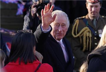 König Charles III. winkt bei seiner Ankunft am Rathaus von Bolton, wo er im Rahmen seines Besuches im Großraum Manchester Vertreter der Gemeinde trifft.