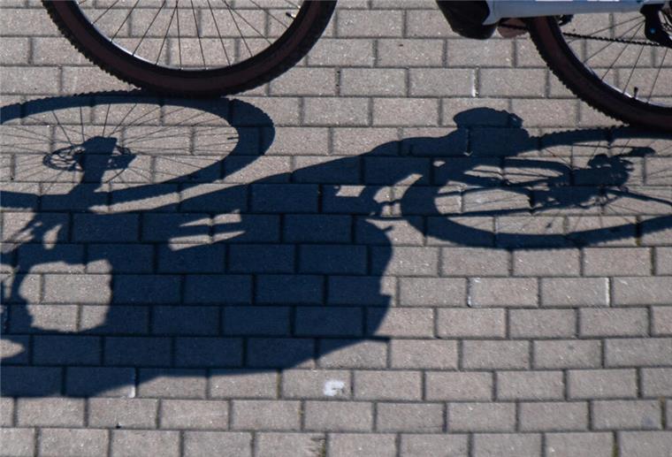 Neues Bikesharing-System in Bremen Schatten eines Radfahrers auf dem Straßenpflaster