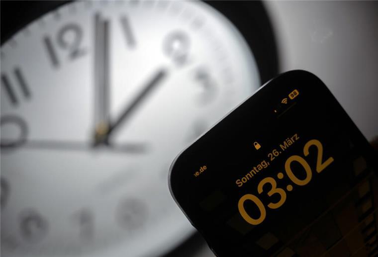 Ihr wollt keine Zeitumstellung mehr: Das sind Eure Antworten Ein Smartphone zeigt die Uhrzeit «03:03» an, während auf einer analogen Uhr noch 02:03 Uhr ist.