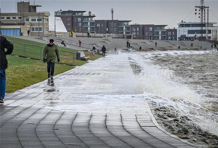 Am Deich tritt die Weser bei Wind und Sturmflutlage über die Uferkante. 