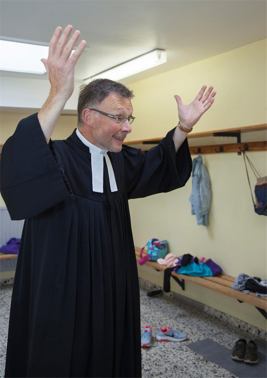Am Kutterhafen in Spieka-Neufeld hat Stephan Büttner, Pastor der evangelisch-lutherischen Kirchengemeinde „Zum guten Hirten“ in Nordholz, schon gepredigt. Die Umkleidekabine in der Turnhalle an der Nordholzer Grundschule wäre eine Premiere (Foto Leuschner). Allerdings keine besonders realistische. Im Fußball kommt es vor, dass Mannschaften in der zweiten Halbzeit wie verwandelt auftreten. Dann wird gerne gemutmaßt, dass die Kabinenpredigt des Trainers „gesessen“ hat. Auf einmal klappt das, was noch in der ersten Hälfte so gar nicht funktionieren wollte. Oft geht es dabei auch laut in der Kabine zu. Eine Kabinenpredigt würde Pastor Büttner eher den deutschen Fans halten: „Zeigt Mitgefühl und schimpft nicht nur.“ Jogis Elf habe „eine ganz schöne Last zu tragen“. Wenn er sich nach dem vergeigten WM-Auftakt gegen Mexiko etwas wünschen könnte, „dann wären das Lahm und Klose“. Dass Fußball und Religion manchmal gar nicht so weit auseinanderliegen, hat Büttner unlängst in einer Sonntagspredigt vor den Nordholzer Gemeindemitgliedern deutlich gemacht – mit der „Fußball-Bibel“ von David Kadel. Darin erzählen Profis, was sie in dieser schillernden Fußballwelt erdet und dankbar macht. Dazu kommen Inhalte der Bibel sowie religiöse Überlegungen zum Thema Fußball und Gott. (ike)