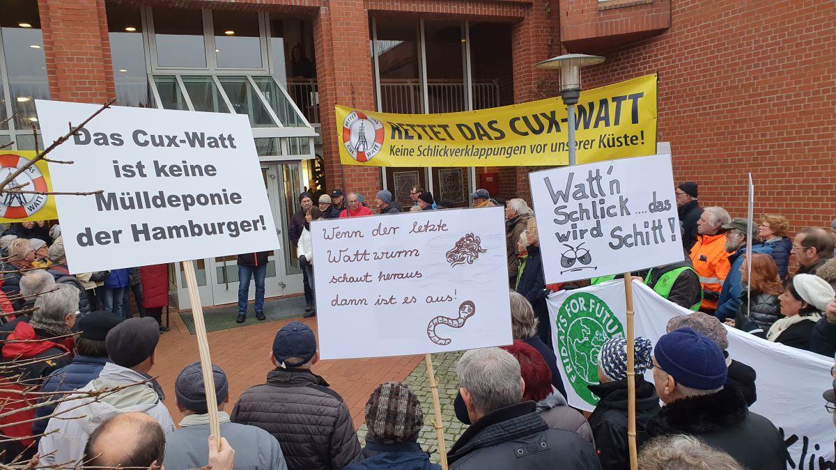 Cuxhaven: Bürger protestieren gegen Verklappung von Baggergut Am liebsten hätten sie ihr Anliegen direkt im Kreishaus vorgetragen. Aber beim Workshop zum Thema Schlick-Watt waren die Umweltschützer von
BUND und NABU nicht willkommen.
