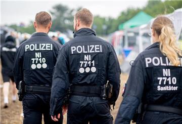 Polizisten gehen über den Zeltplatz des Deichbrand Festivals. 