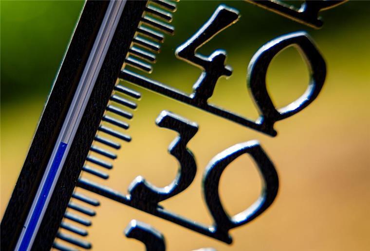  Vor einem wolkenlosen blauen Himmel zeigt ein Außenthermometer in einem Garten bereits am Vormittag über 30 Grad Lufttemperatur an. 
