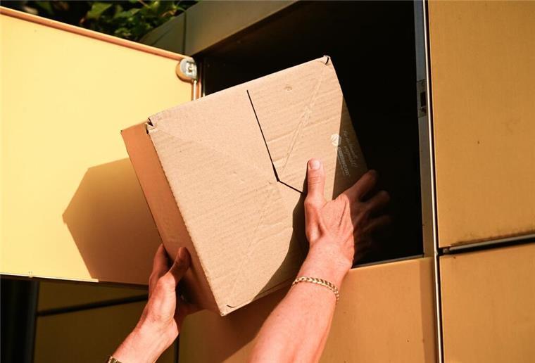 Amazon testet große Änderung bei den Versandkosten! Viele Kunden müssen mehr zahlen Eine Person holt ein Paket aus einer Packstation.