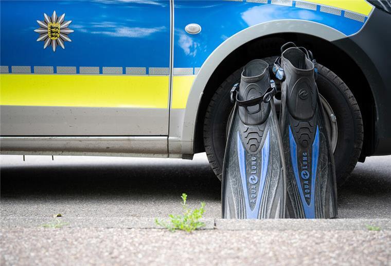 Vermisster Stand-up-Paddler ist tot: Taucher bergen Leiche Flossen eines Polizeitauchers stehen an einem Polizeiauto
