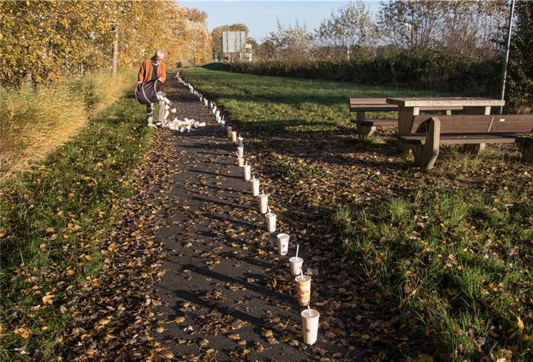 Müll an der B 6: Rentner kämpft dagegen an Zahlreiche Pappbecher sind in einer Reihe auf einem Weg aufgestellt.