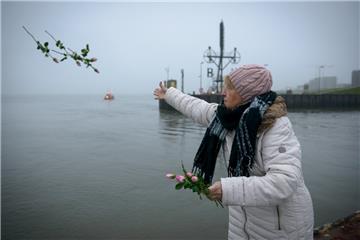 An der Nordmole warfen Trauernde Blumen für ihre verstorbenen Angehörigen ins Wasser.
