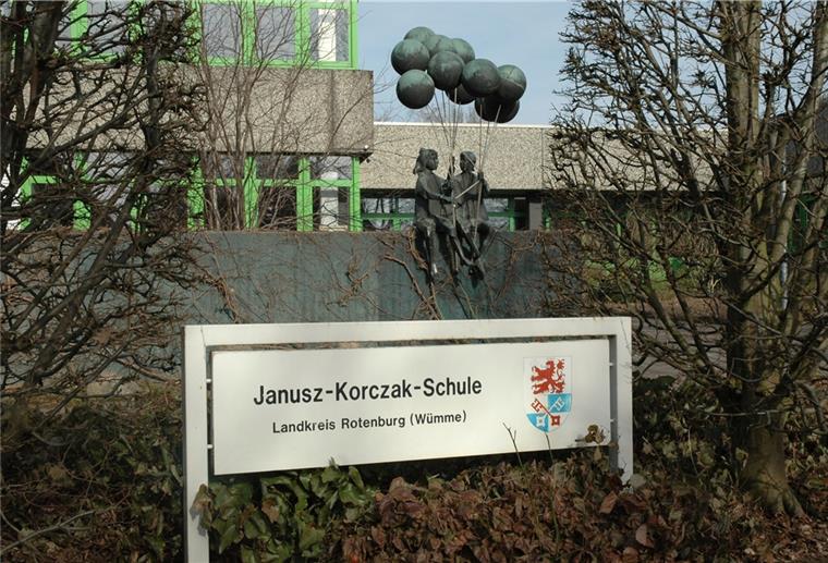 Ein Schild steht vor einer Plastik, die vor dem Gebäude der Janusz-Korczak-Schule in Zeven steht.
