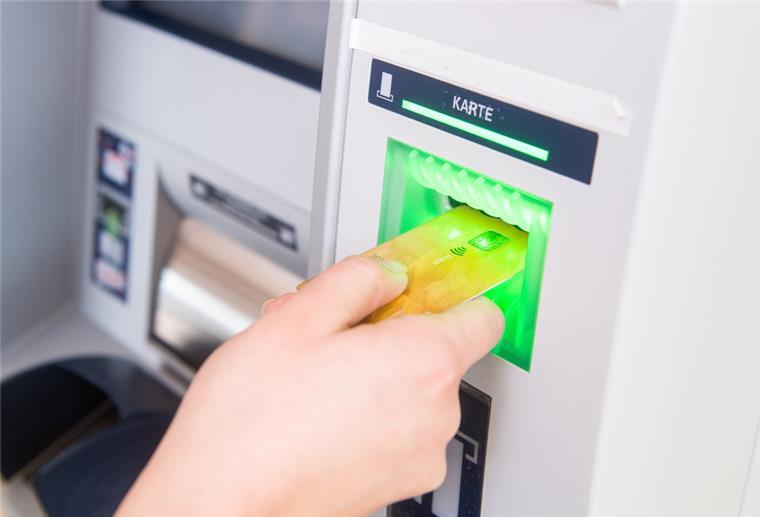 Bargeld könnte an Bankautomaten Mangelware werden Bankkarte wird in Geldautomat eingeführt.