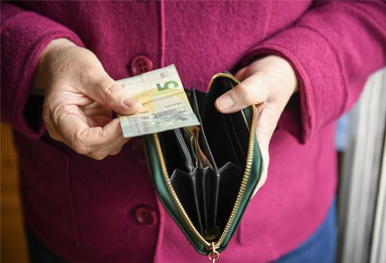  Eine ältere Frau hält eine mit einigen Geldscheinen gefüllte Geldbörse in einer Hand und einen Fünf-Euro-Schein in der anderen Hand, Andere Länder sind bei der Rente weit voraus: Niederlande, Österreich und Dänemark bieten deutlich höhere Rentenniveaus – und zeigen, was möglich ist, wenn alle einzahlen und langfristig gedacht wird.