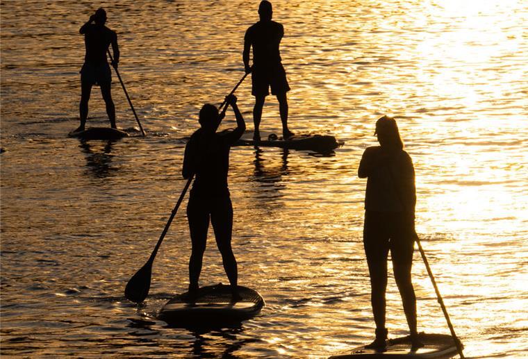 SUP-Tour nach Bremerhaven: 4 Männer paddeln 431 Kilometer nonstop auf der Weser Mehrere Stand-Up-Paddler sind auf einem See unterwegs.