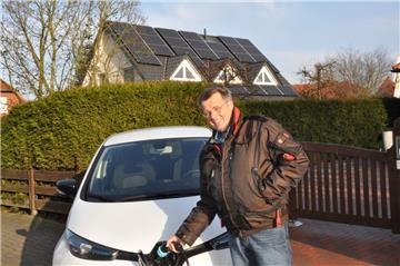 Andreas Wedelich mit seinem Elektroauto vor seinem Haus in Nordenham. Den Strom bezieht er von den Solarmodulen auf dem Dach.
