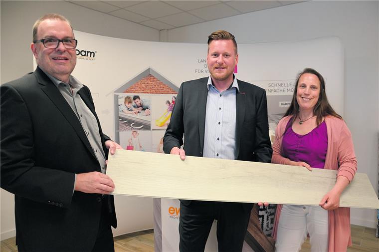 Anfassen ist erlaubt: Bürgermeister Thorsten Krüger (links) und Katja Beier von der städtischen Wirtschaftsförderung lassen sich erklären, was es Besonderes mit dieser Bodenplatte aus Vinyl auf sich hat. Prokurist und Vertriebsleiter Christoph Sawalies (Mitte) ist in seinem Element.