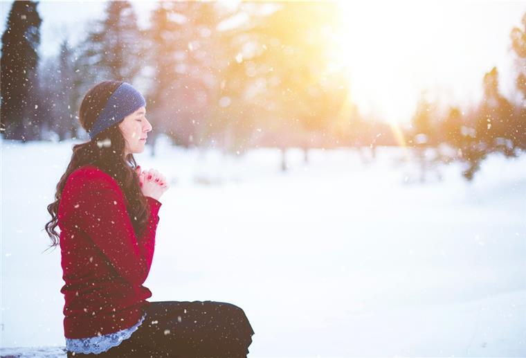 Frau meditiert im Schnee