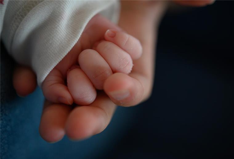 Niedersachsen: Werdende Eltern haben immer weitere Wege zum Kreißsaal Die Hand eines zwei Wochen alten Neugeborenen liegt in der Hand seiner Mutter.