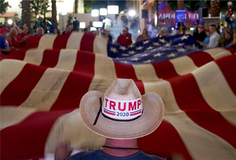 Knappes Rennen zwischen Trump und Biden Anhänger von Präsident Donald Trump schwenken während einer Wahlparty eine Flagge.
